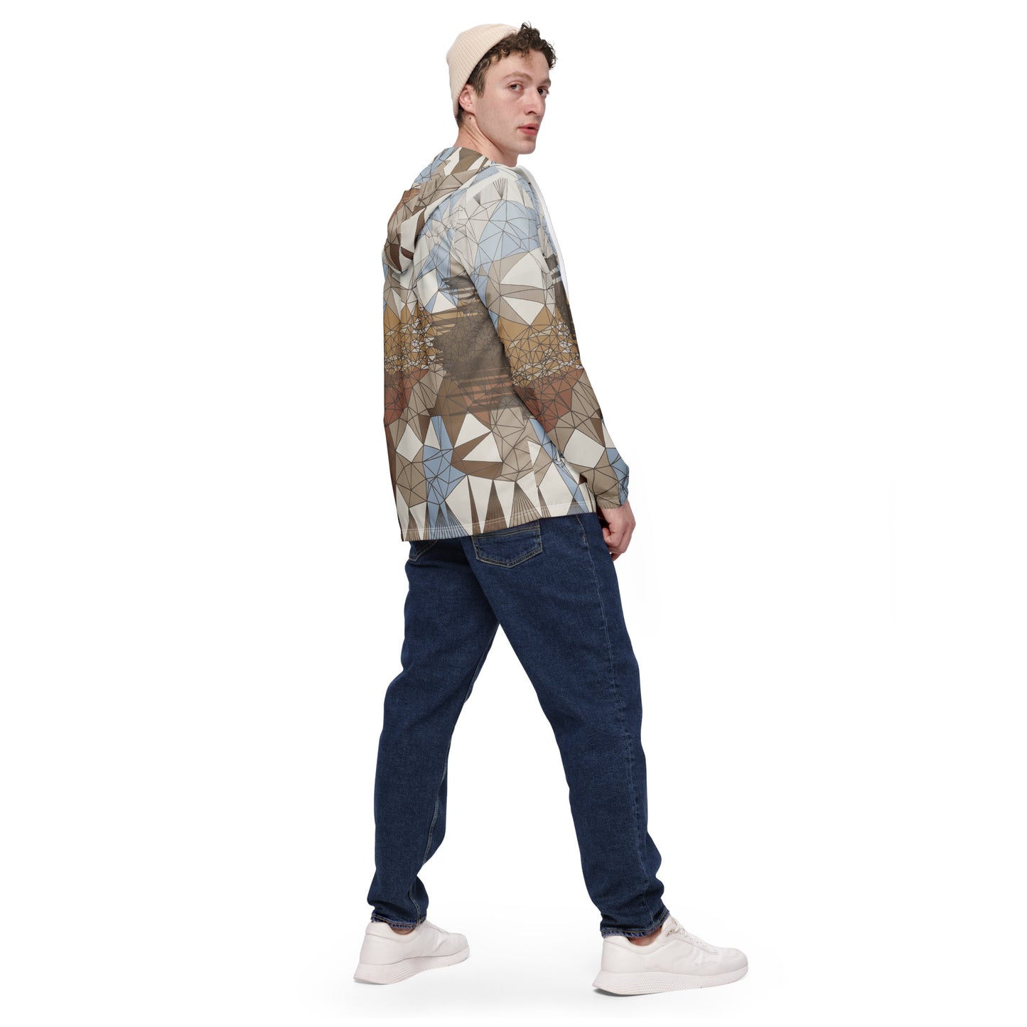 Person wearing an abstract patterned windbreaker and jeans on a white background
