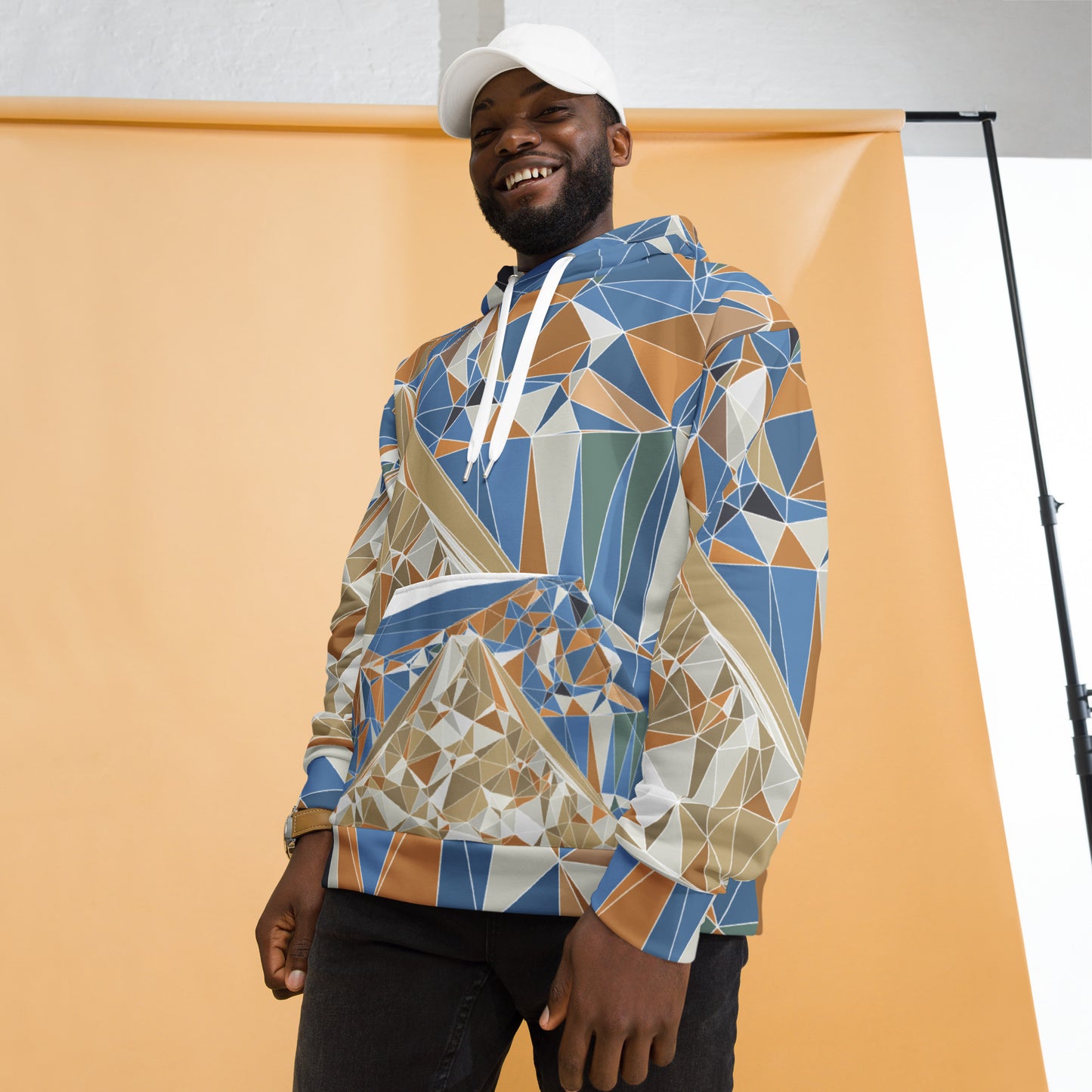 Person wearing a colorful geometric-patterned hoodie with Mount Fuji graphic against an orange background